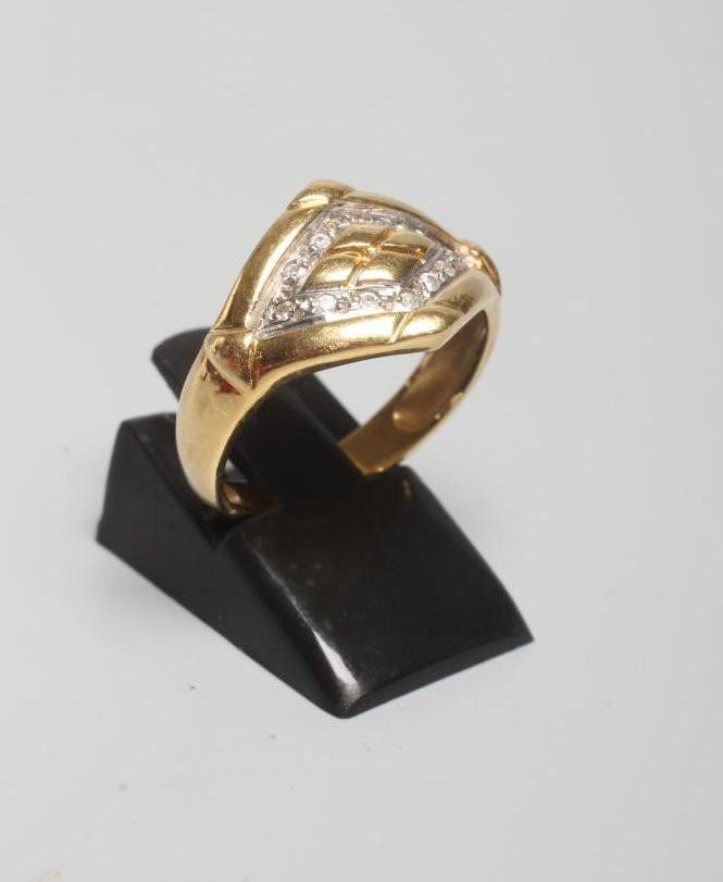 A DIAMOND SET SIGNET RING, the lozenge panel pave set with twelve diamond points enclosing a Image