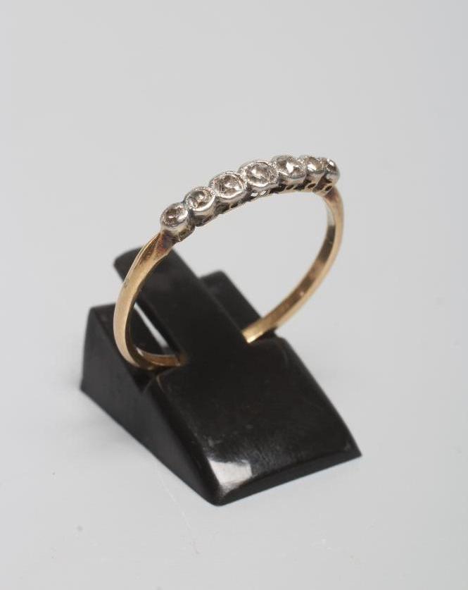 A SEVEN STONE DIAMOND HALF HOOP RING, the graduated mixed cut stones collet set to a plain shank, Image