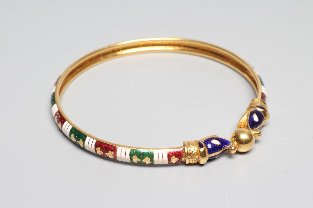 A BANGLE, unmarked but probably Egyptian, with red, white and green enamelled arcading and snake Image