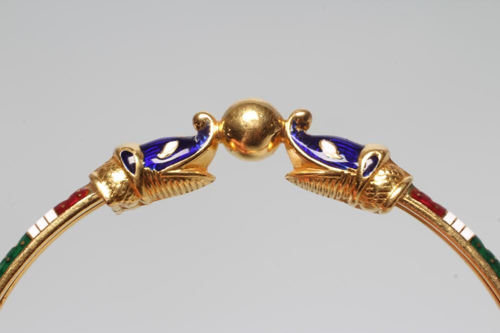 A BANGLE, unmarked but probably Egyptian, with red, white and green enamelled arcading and snake Image