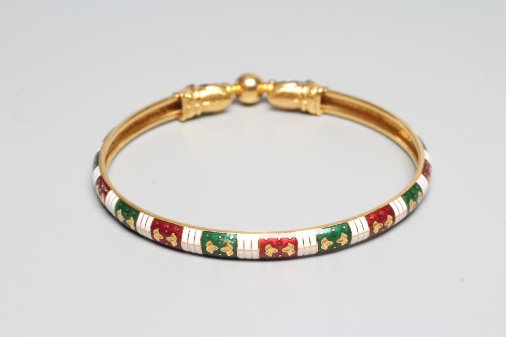A BANGLE, unmarked but probably Egyptian, with red, white and green enamelled arcading and snake Image