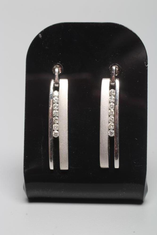 A PAIR OF 18CT WHITE GOLD AND DIAMOND DROP EAR STUDS of elongated oblong form with one matt and one Image