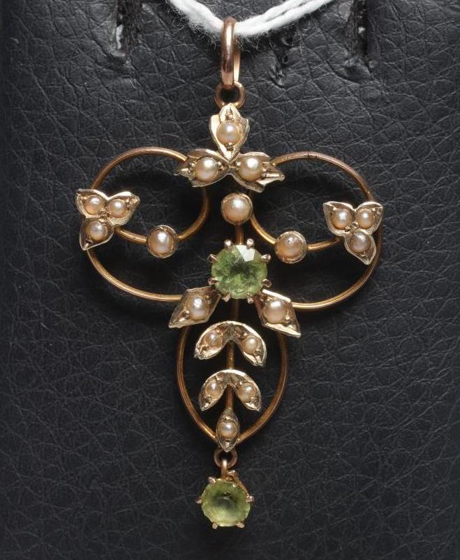 AN EDWARDIAN OPEN WIREWORK TREFOIL PENDANT centred by two facet cut peridots and with seed pearl set Image