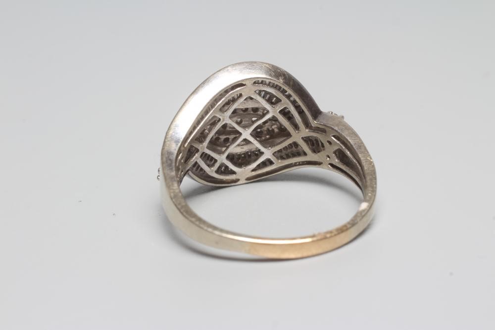 A DIAMOND COCKTAIL RING, the entwined panel point set with numerous small brilliant and baguette cut Image
