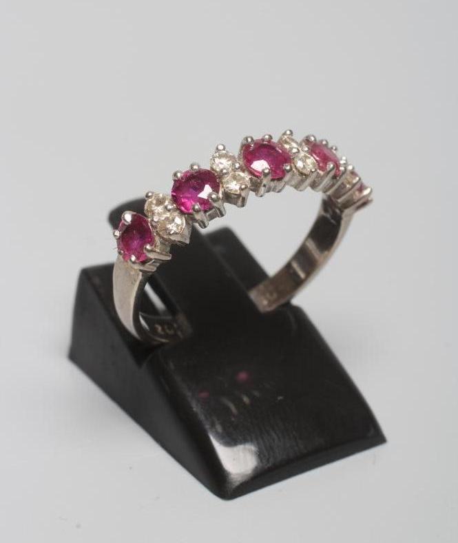 A RUBY AND DIAMOND HALF HOOP RING, the five round facet cut rubies claw set with four pairs of small Image