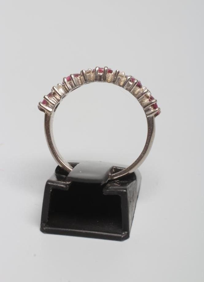 A RUBY AND DIAMOND HALF HOOP RING, the five round facet cut rubies claw set with four pairs of small Image