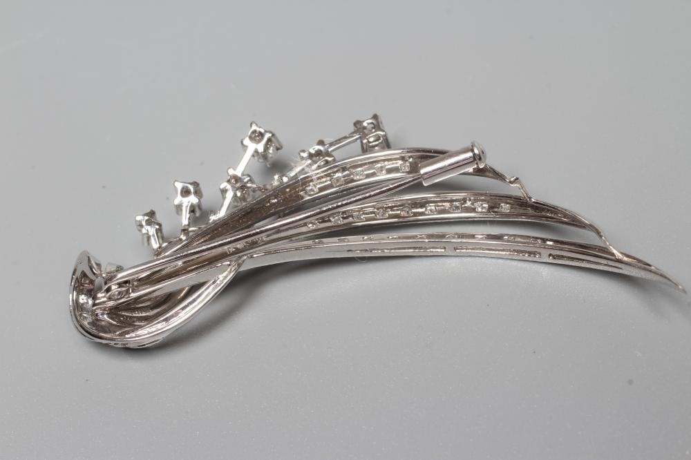 A DIAMOND SPRAY BROOCH, the three stylised curved leaves point set with graduated small stones and Image