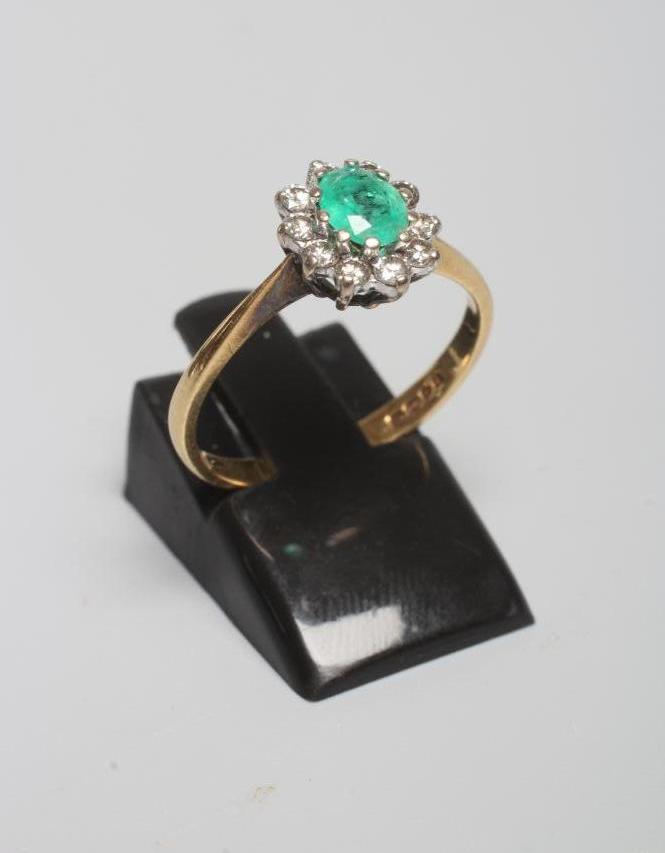 AN EMERALD AND DIAMOND CLUSTER RING Image