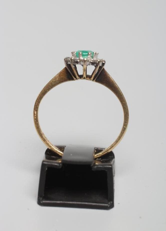 AN EMERALD AND DIAMOND CLUSTER RING Image