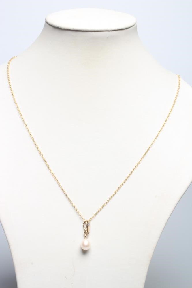 A CULTURED PEARL PENDANT, the white oval pearl peg set to a triangular 9ct gold bale set with a Image