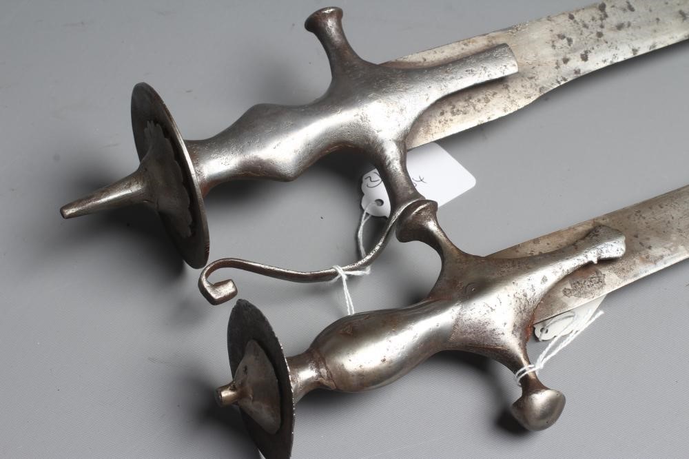 TWO INDIAN TALWAR both with curved blades, extended langets, twin quillon and disc pommels, one with Image