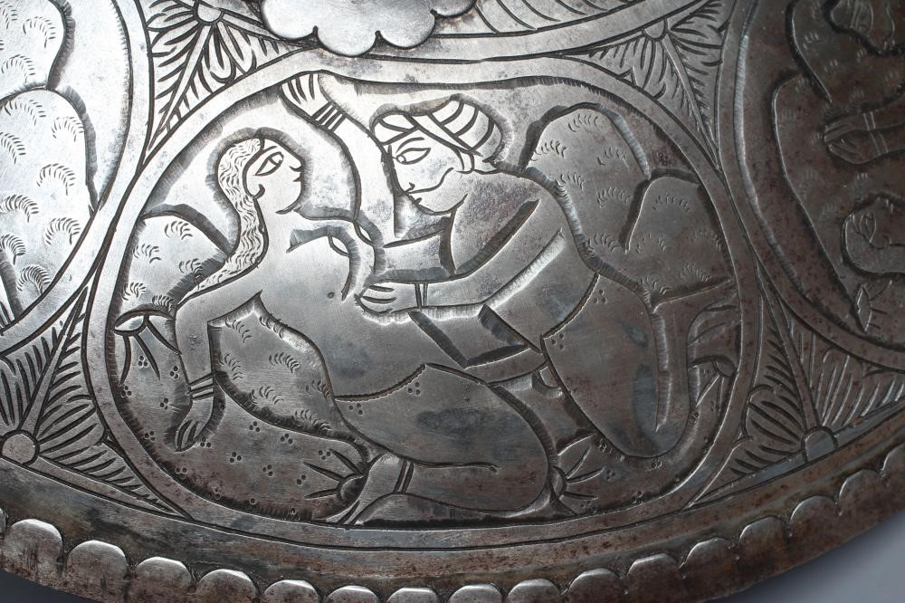 AN INDIAN STEEL CIRCULAR DHAL SHIELD with four bosses and decorated with erotic scenes, 17" diameter Image
