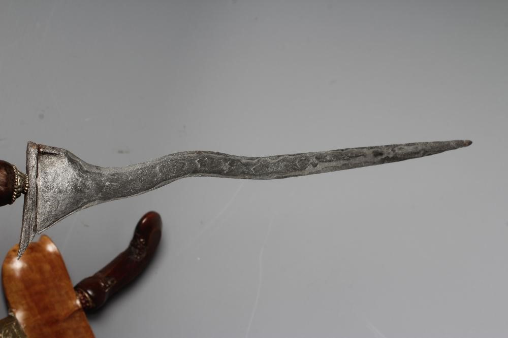THREE INDONESIAN KRIS DAGGERS with shaped and laminated steel blades, carved grips and typical two Image