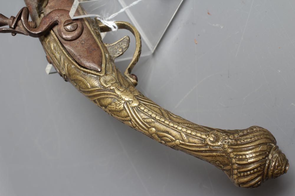 A FLINTLOCK PISTOL with 12" barrel, plain action and highly decorative foliate designed brass stock, Image