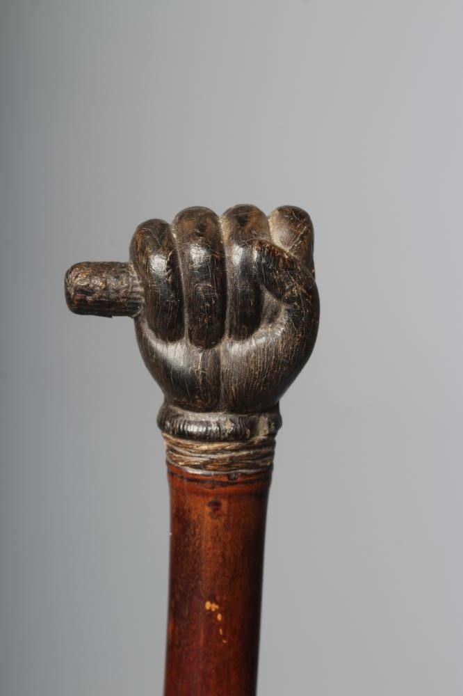 A SWAGGER SWORD STICK, 19th century, with 17 3/4" square section blade, pommel carved as a clenched Image
