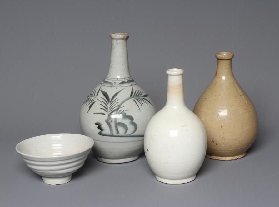 THREE CHINESE STONEWARE BALUSTER VASES, one painted in underglaze blue with stylised bamboo, 10" Image