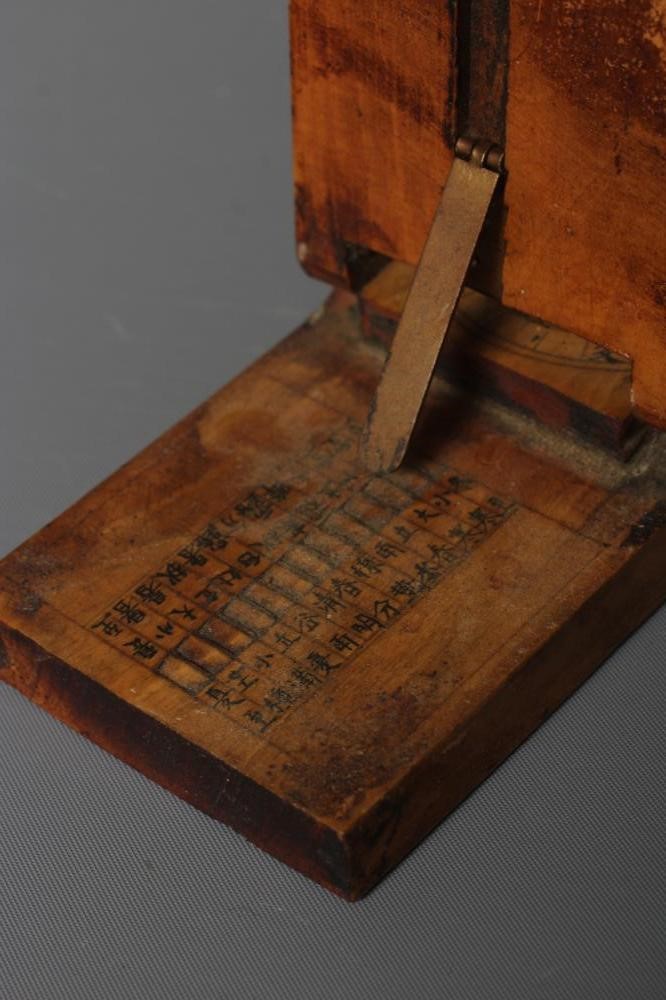 A CHINESE WOOD COMPASS FLANKED BY TWO SUNDIALS Image