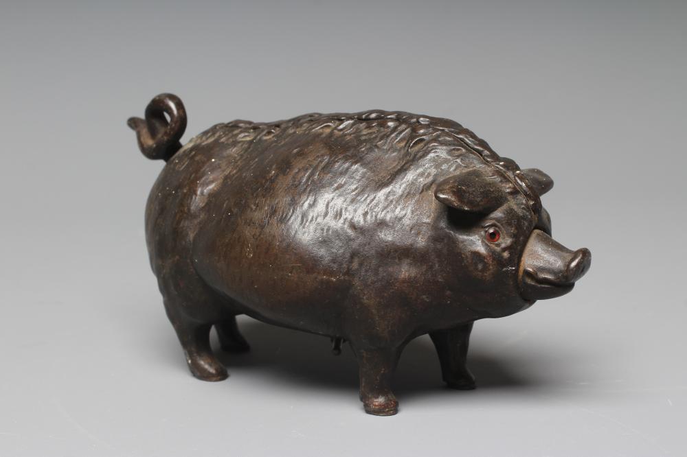 A BUTCHER'S SHOP CAST IRON PIG COUNTER BELL, late Victorian, with amber glass eyes, the clockwork Image