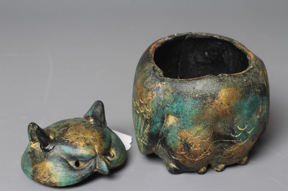 A JAPANESE GREEN PATINATED METAL OWL BOX, modern, the head forming the cover, with gilded Image