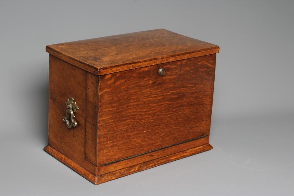 AN EDWARDIAN OAK STATIONERY BOX of oblong form with lightly domed hinged lid and two brass handles Image