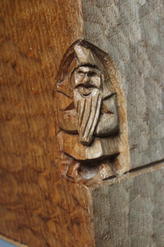 A THOMAS WHITTAKER FIGURAL BOOKEND carved as a friar reading a book and seated in an ecclesiastical Image