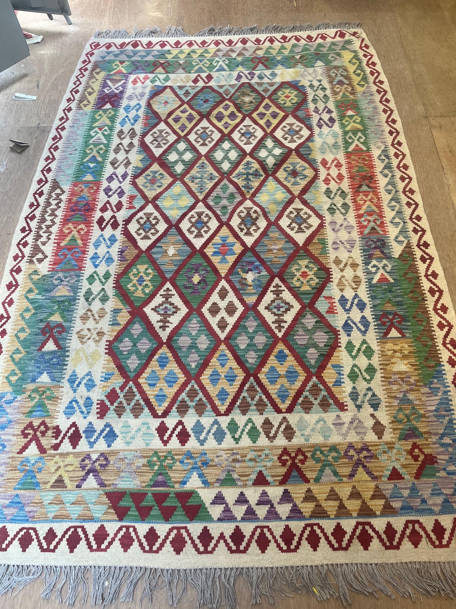 AN AFGHAN KILIM FLAT WEAVE WOOL RUG, modern, woven in polychrome in a geometric diamond pattern, the Image