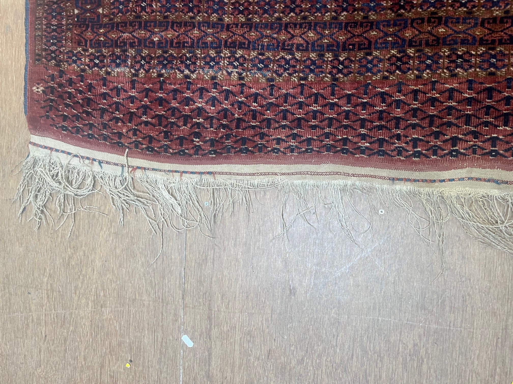 A TEKKE DESIGN RUG, the madder field with a repeating pattern of three rows of quartered Guls within Image