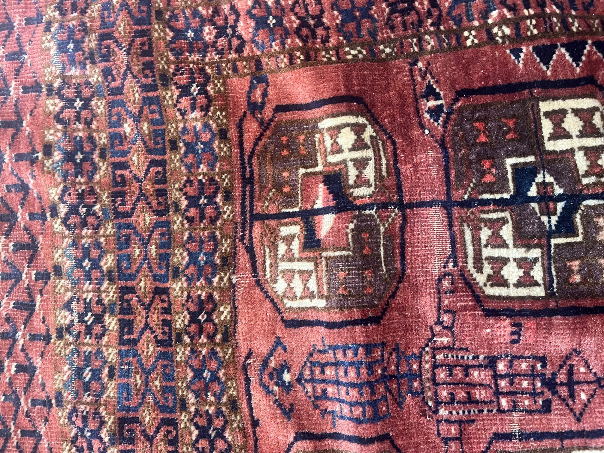A TEKKE DESIGN RUG, the madder field with a repeating pattern of three rows of quartered Guls within Image