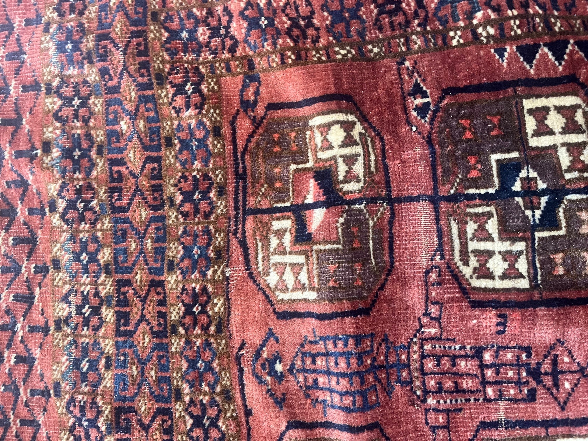 A TEKKE DESIGN RUG, the madder field with a repeating pattern of three rows of quartered Guls within Image
