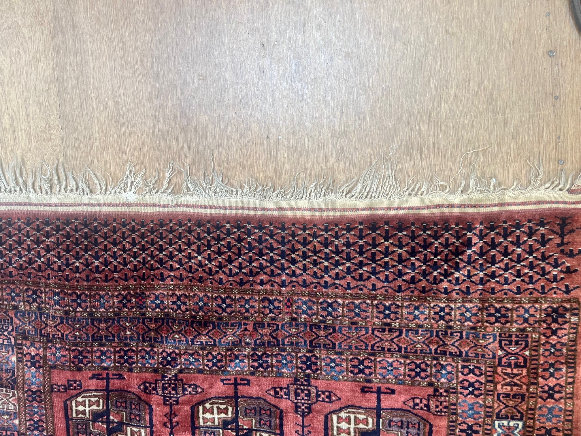 A TEKKE DESIGN RUG, the madder field with a repeating pattern of three rows of quartered Guls within Image