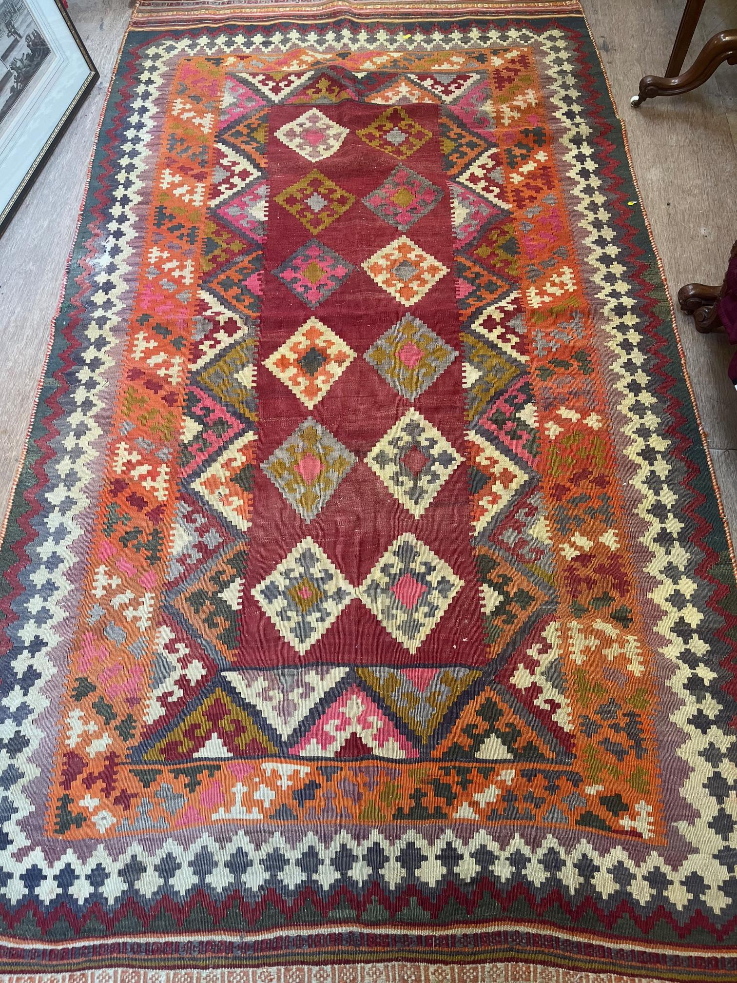 A TURKISH KILIM, latter half 20th century, the red field with repeating polychrome gul pattern Image