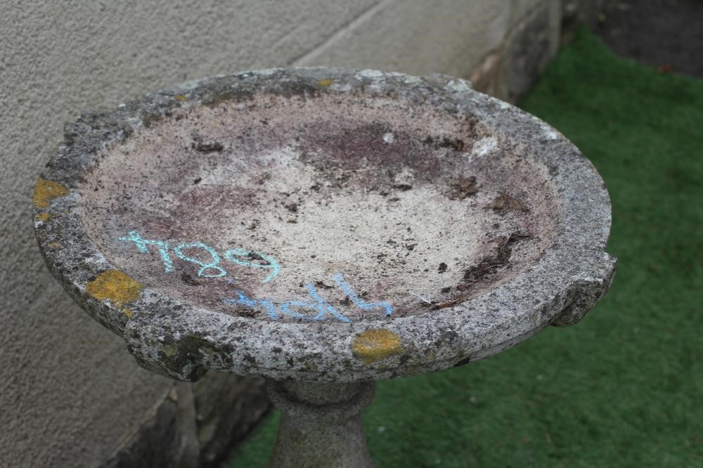 A CAST STONE BIRD BATH, the shallow circular bowl raised on turned baluster stem and stepped square Image