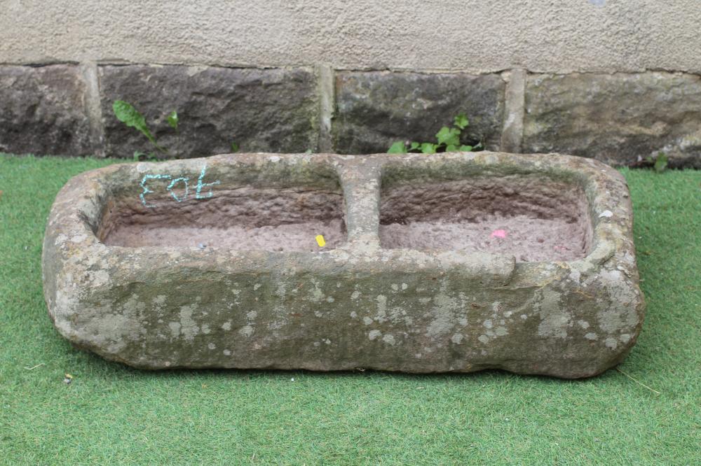 A SANDSTONE TROUGH of rough hewn tapering oblong form with central division, 39" w x 16 1/2" d Image