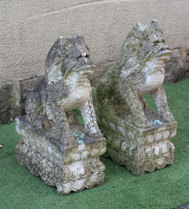 A PAIR OF CAST STONE SEATED BUDDHISTIC LIONS on an oblong base with egg and dart banding, 14 1/2" w Image