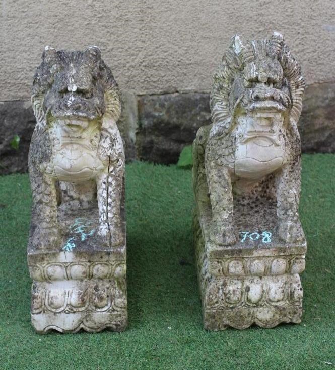 A PAIR OF CAST STONE SEATED BUDDHISTIC LIONS on an oblong base with egg and dart banding, 14 1/2" w Image