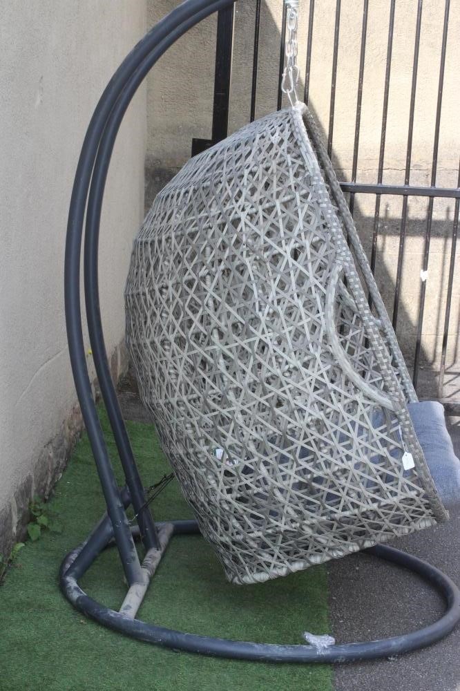A POLYRATTAN EGG CHAIR, modern, suspended by chain from a tubular metal frame with circular base, 51 Image