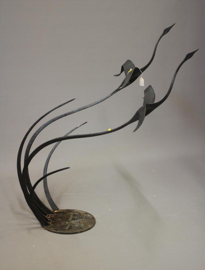 A BLACK PATINATED METAL GARDEN SCULPTURE, modern, modelled as two geese in flight emerging from a Image