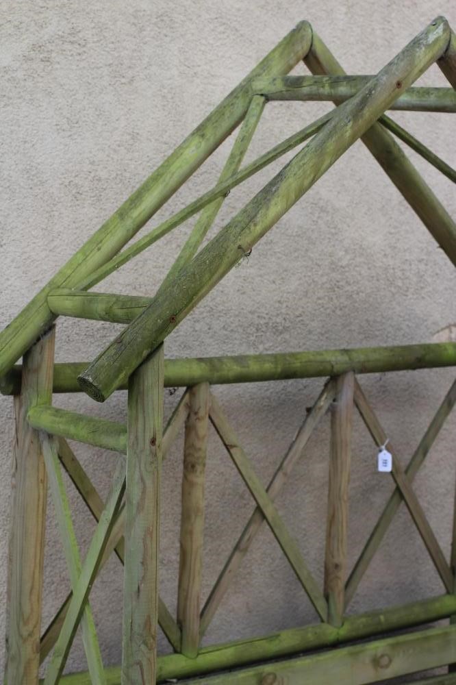 A TWO SEATER SOFT WOOD ARBOUR with arched top and trellis sides, 58 1/2" w x 20" d x 88" h Image