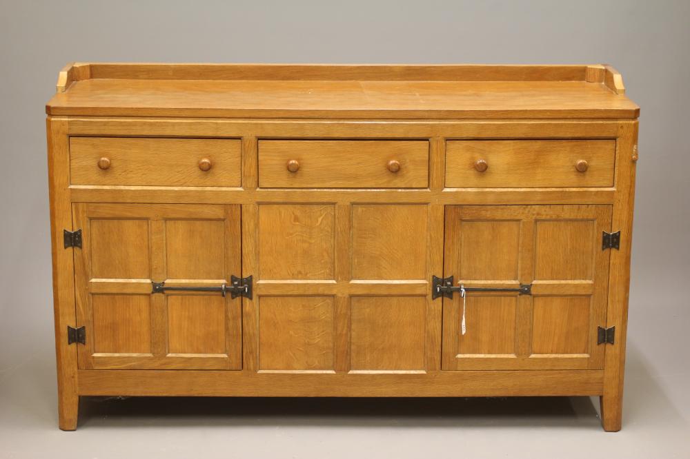 PETER HEAP OF WETWANG - AN ADZED OAK ENCLOSED DRESSER of multi-panelled canted oblong form Image