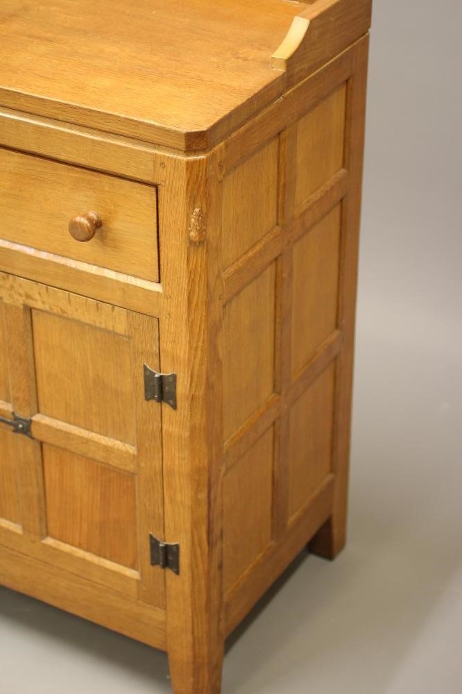 PETER HEAP OF WETWANG - AN ADZED OAK ENCLOSED DRESSER of multi-panelled canted oblong form Image