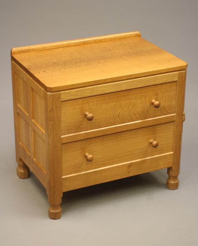ROBERT THOMPSON - AN ADZED OAK BEDSIDE CHEST of canted oblong form Image