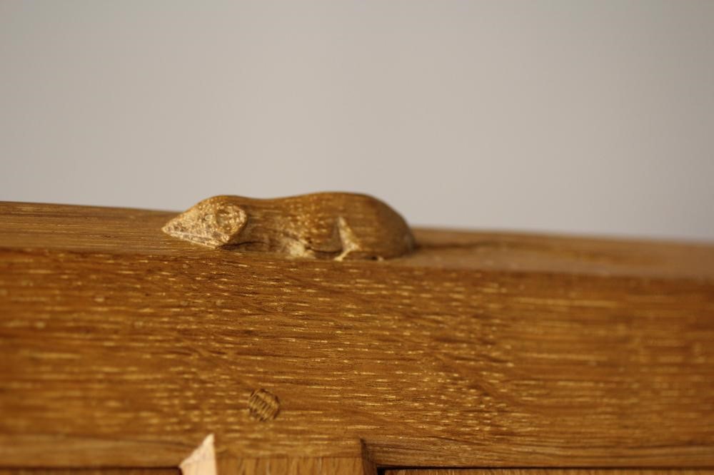 ROBERT THOMPSON - AN ADZED OAK BEDSIDE CHEST of canted oblong form Image