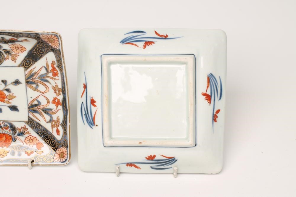 A PAIR OF IMARI PORCELAIN SQUARE DISHES painted in typical palette with panels of iris and potted Image