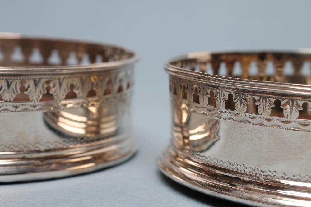 A LATE GEORGE III SILVER BOTTLE COASTER Image