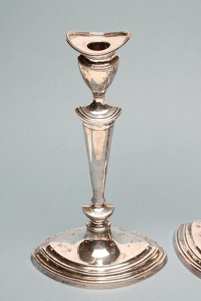 A COMPOSITE PAIR OF EDWARDIAN SILVER CANDLESTICKS Image