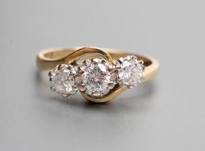 A THREE STONE DIAMOND CROSSOVER RING Image