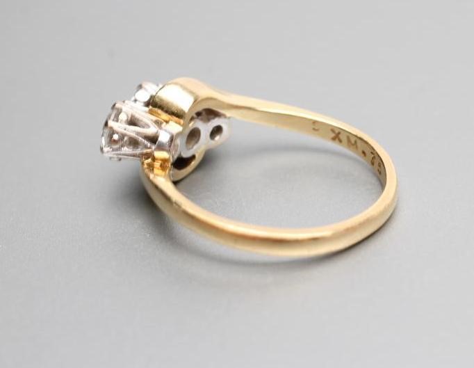 A THREE STONE DIAMOND CROSSOVER RING Image