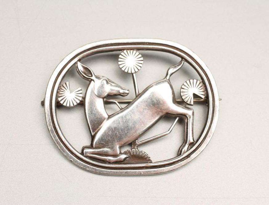 A GEORG JENSEN "KNEELING DEER" SILVER BROOCH designed by Arno Malinowski Image