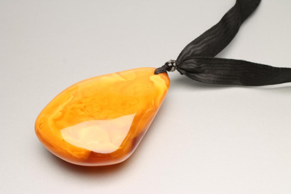 A LARGE POLISHED AMBER PENDANT Image