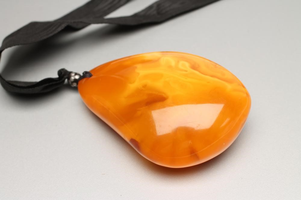 A LARGE POLISHED AMBER PENDANT Image